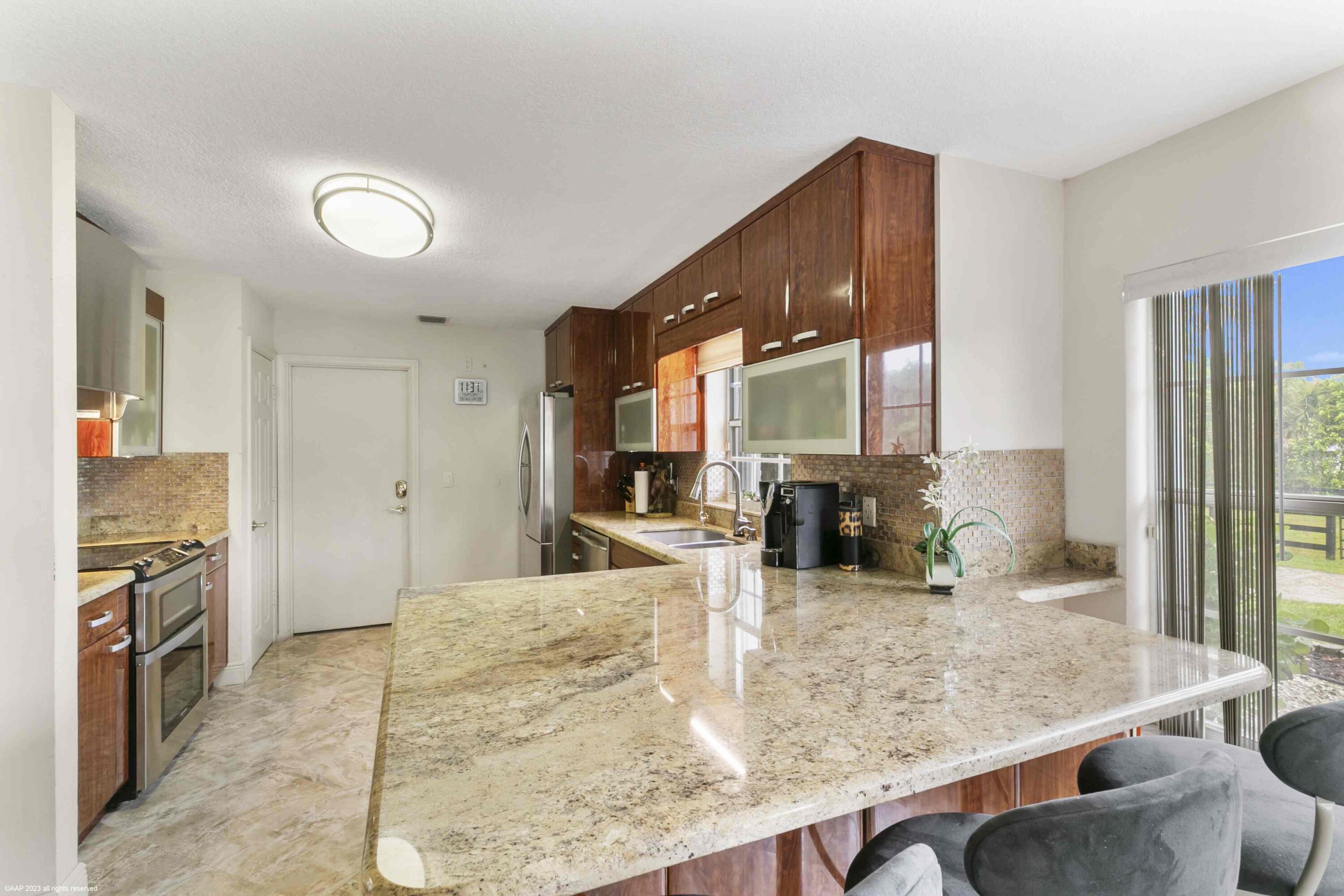 16559 Rustic Road Wellington, FL 33470 - Photo 58 of 82 a kitchen with stainless steel appliances granite countertop wooden cabinets a stove and a sink