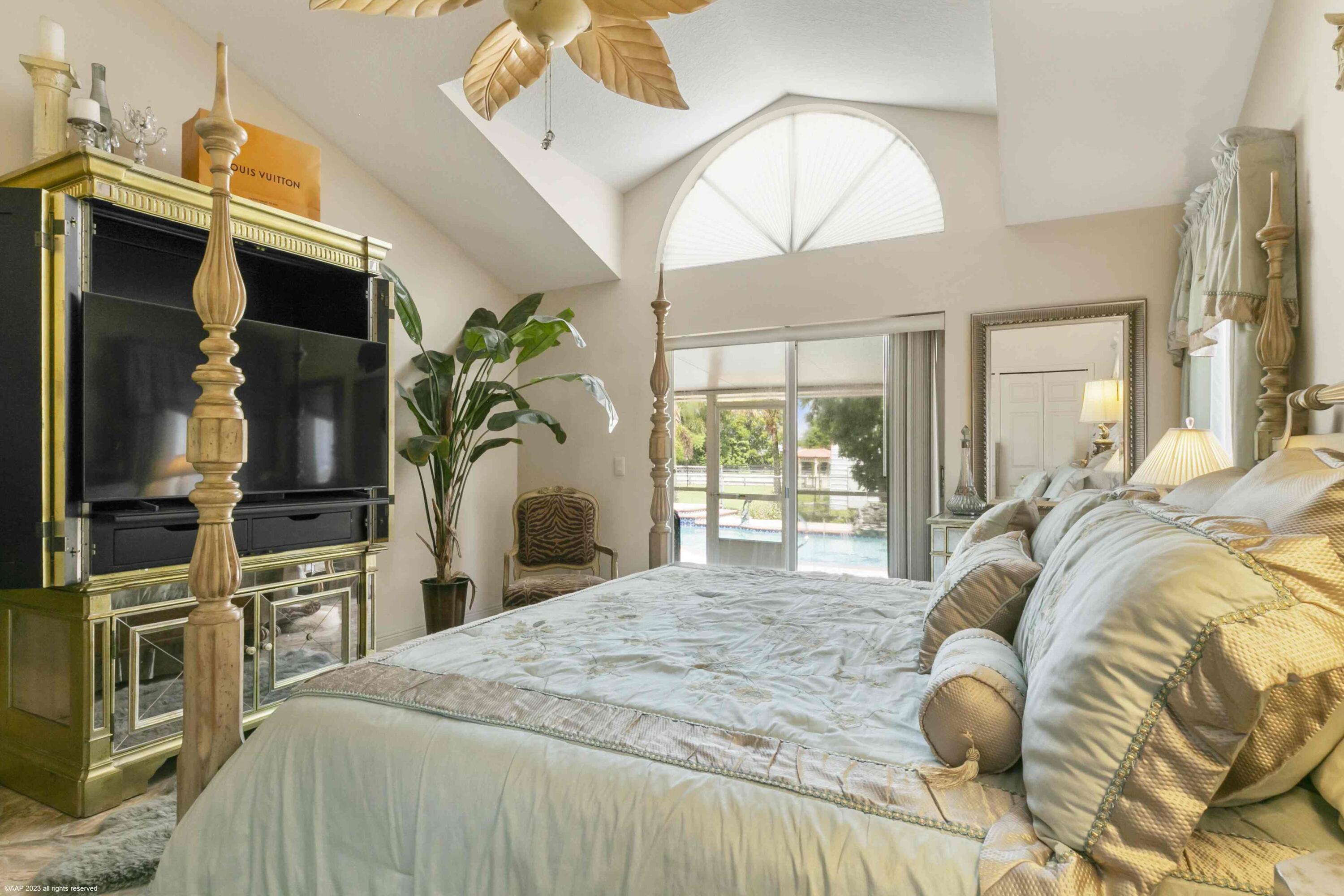 16559 Rustic Road Wellington, FL 33470 - Photo 62 of 82 a bedroom with a bed wooden floor and flat screen tv
