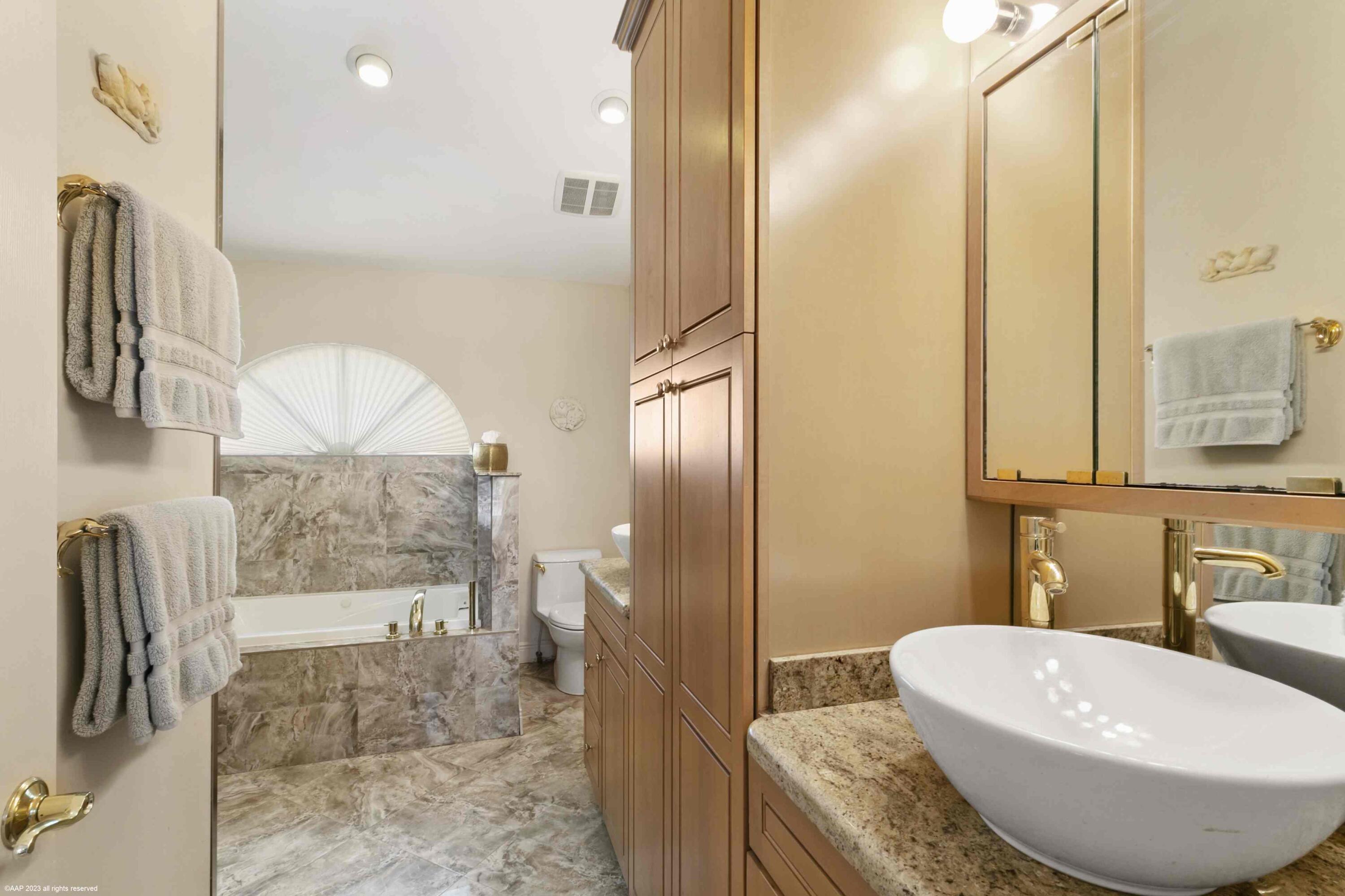 16559 Rustic Road Wellington, FL 33470 - Photo 63 of 82 a bathroom with a granite countertop bathtub sink and mirror