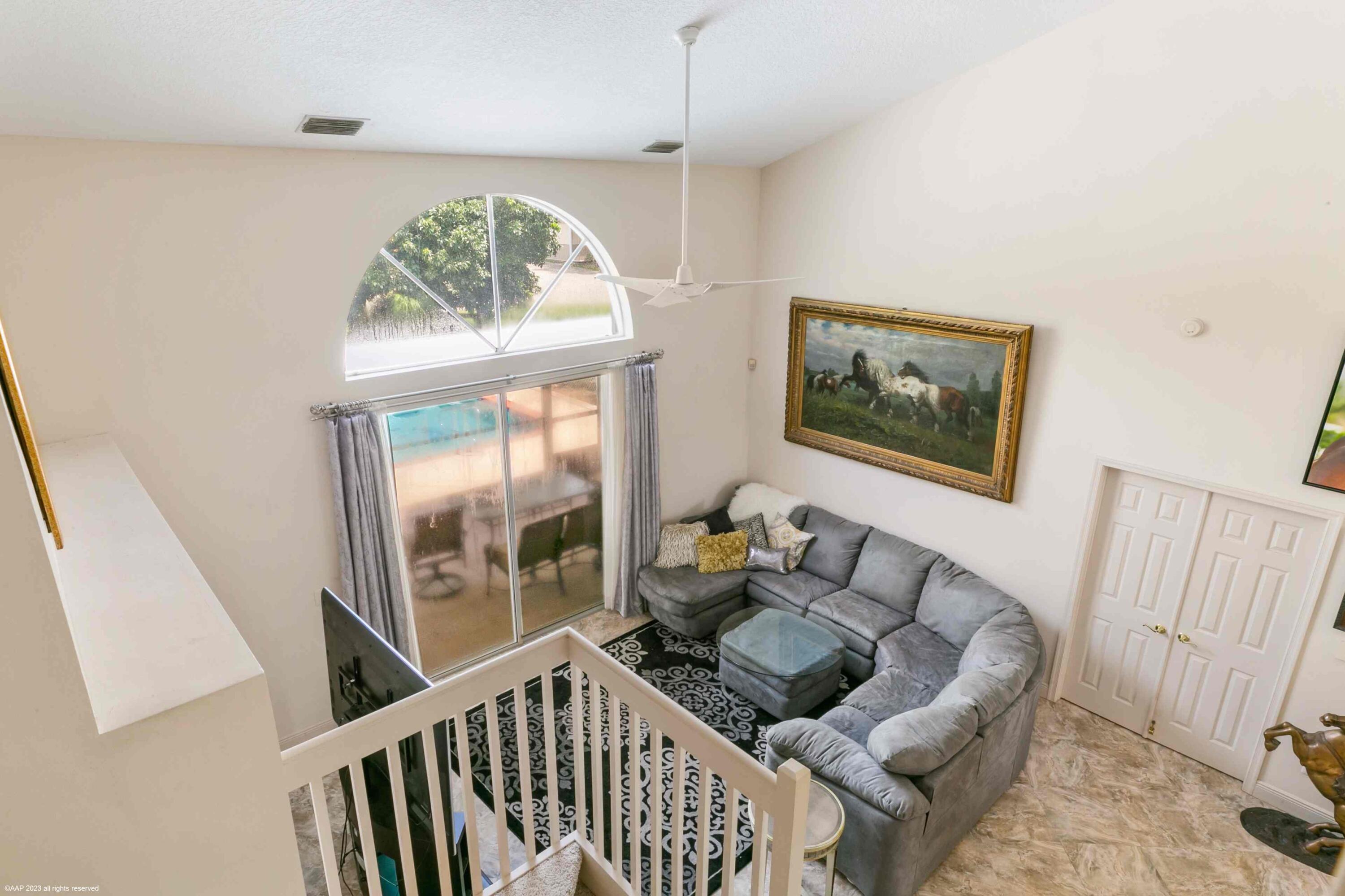 16559 Rustic Road Wellington, FL 33470 - Photo 65 of 82 a living room with furniture and a large window