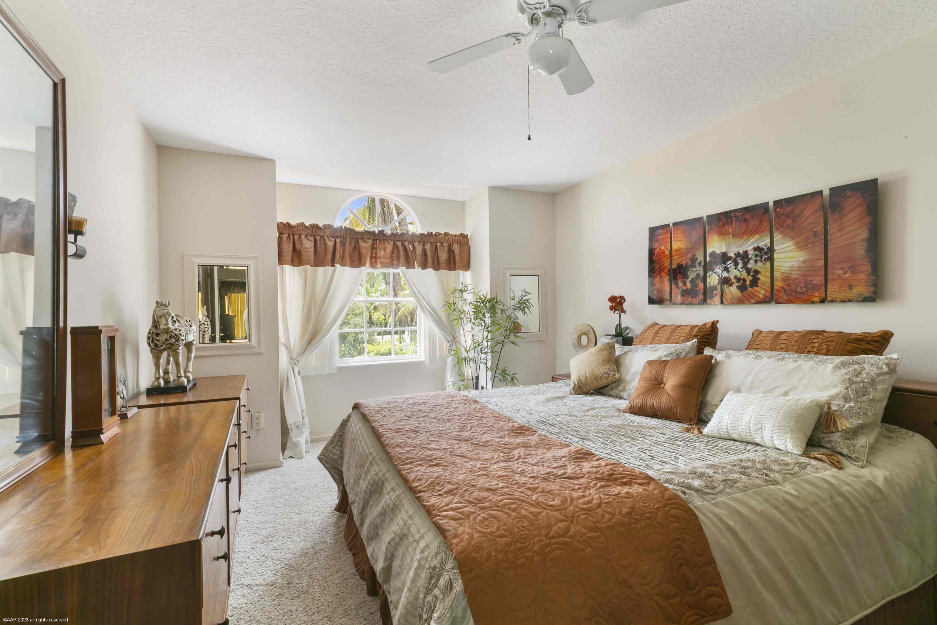 16559 Rustic Road Wellington, FL 33470 - Photo 66 of 82 a bedroom with a large bed and a chandelier