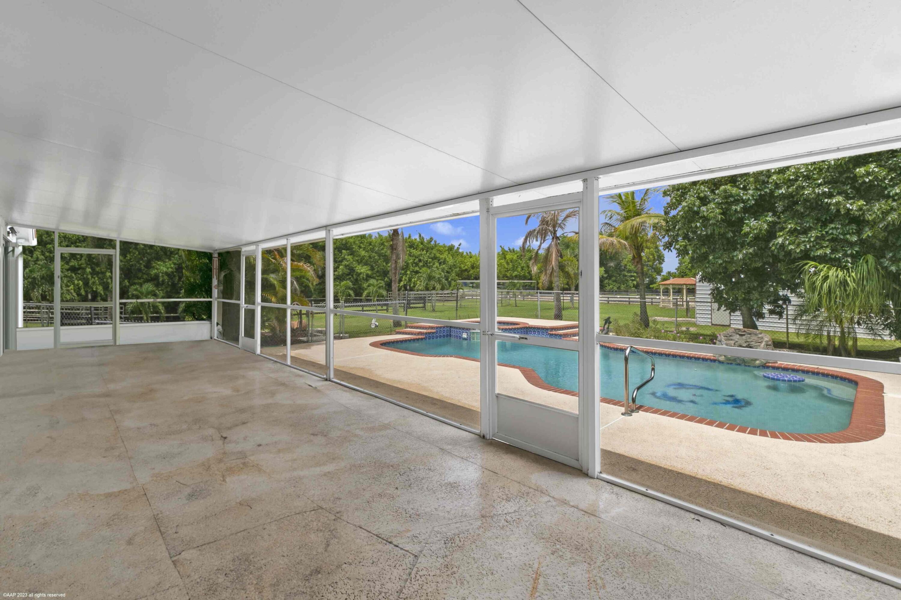 16559 Rustic Road Wellington, FL 33470 - Photo 74 of 82 a view of an empty room with floor to ceiling windows and yard