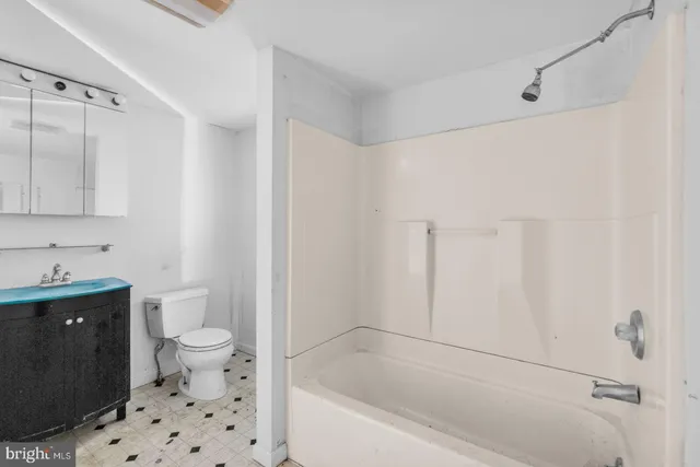 a bathroom with a granite countertop sink a toilet and shower