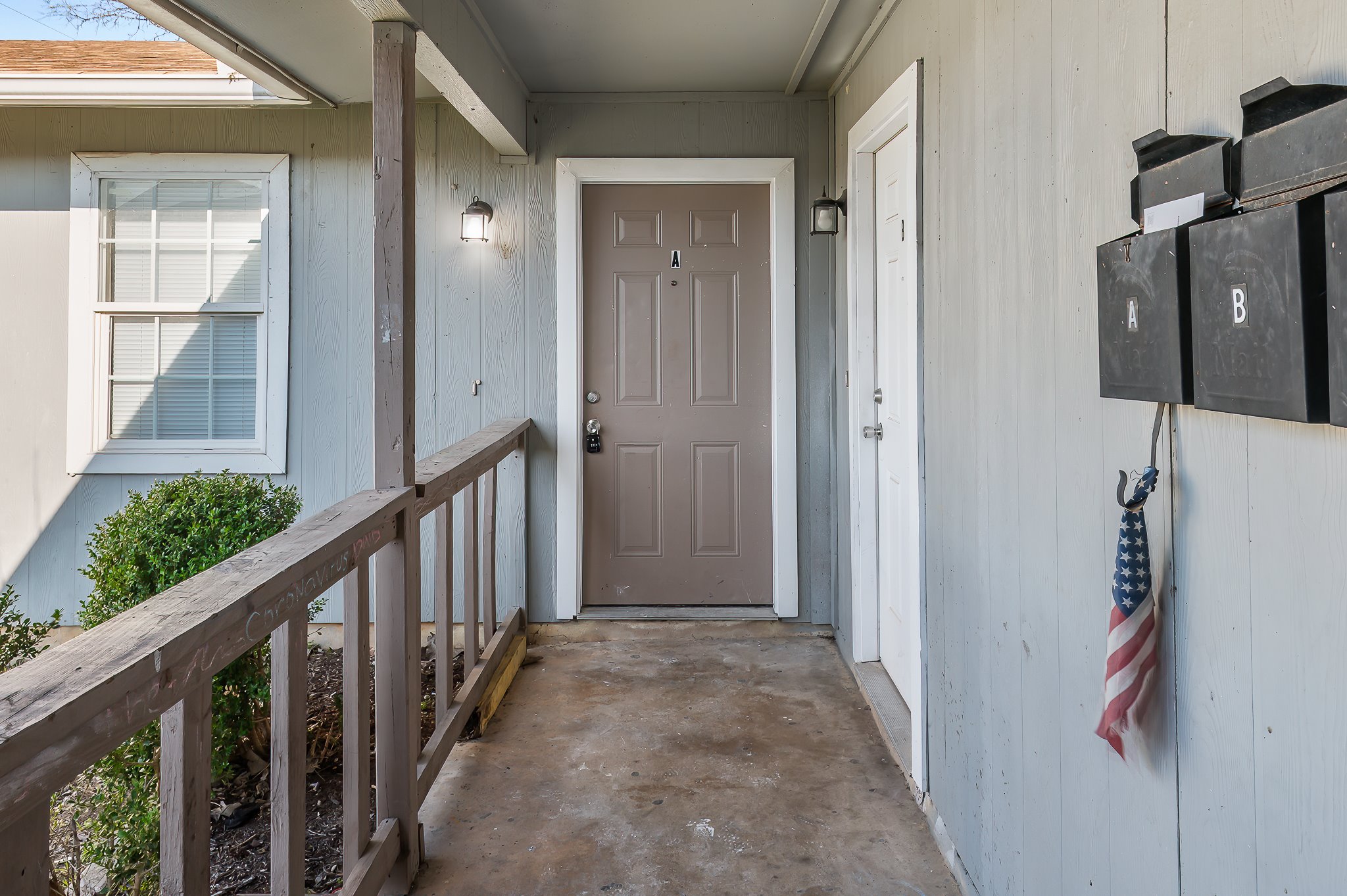 410 Old Thorndale Road, Unit D Taylor, TX 76574 - Photo 6 of 14 Covered entry porch featuring a wood railing and concrete flooring
