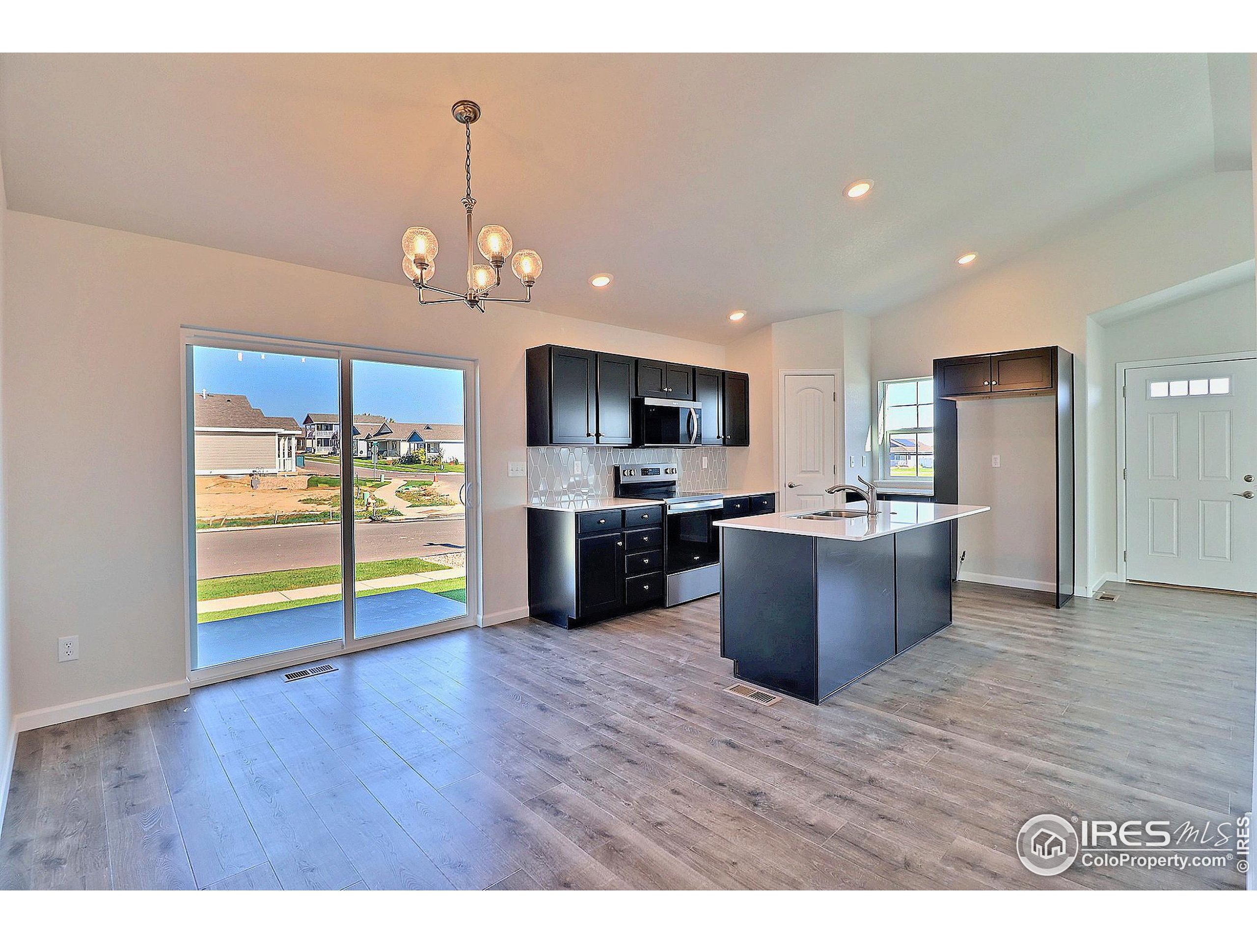 4301 Rockcress Road Evans, CO 80620 - Photo 11 of 26 a view of kitchen with stainless steel appliances granite countertop a refrigerator a sink dishwasher and a stove with wooden floor