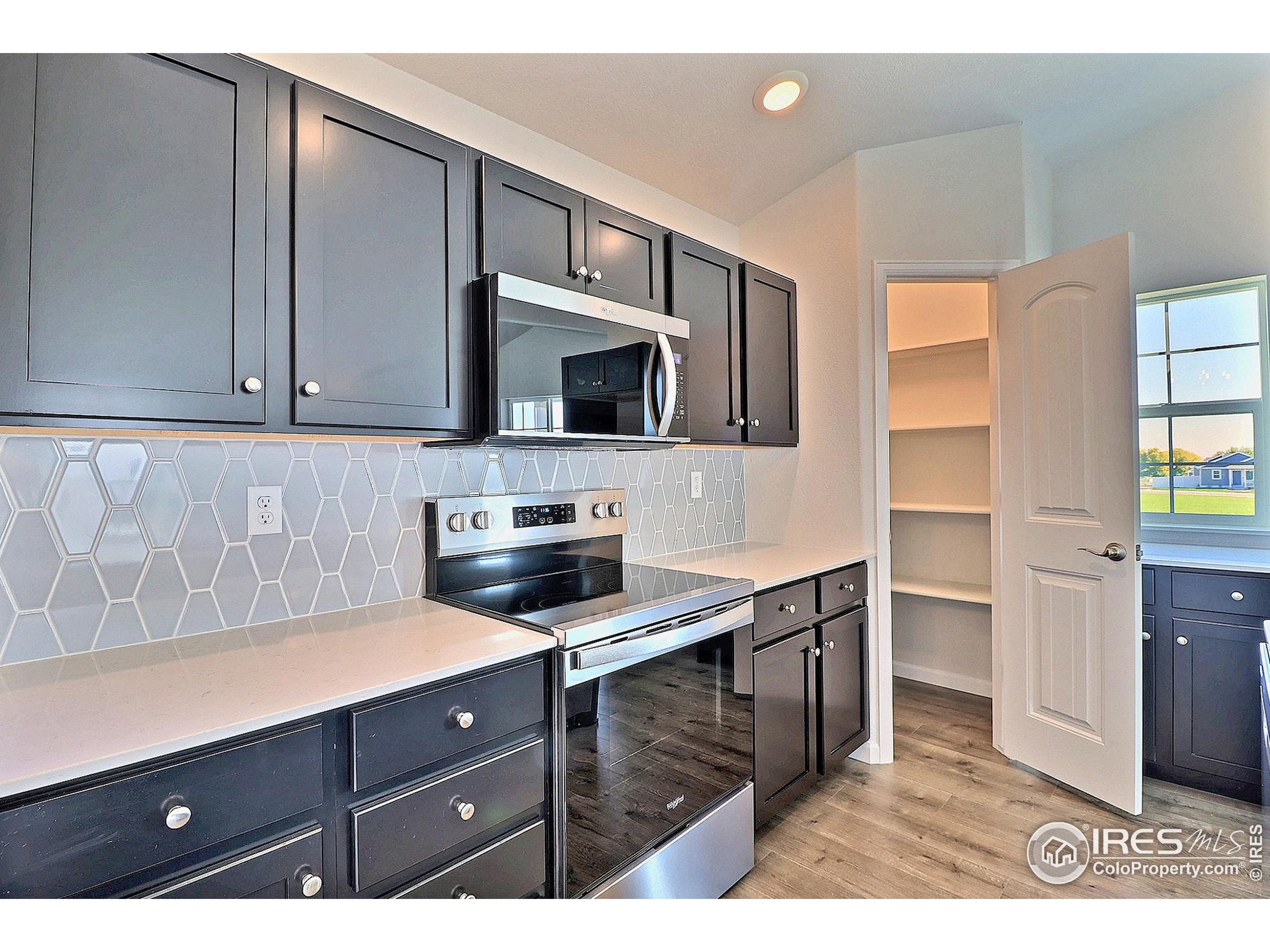 4301 Rockcress Road Evans, CO 80620 - Photo 15 of 26 a kitchen with stainless steel appliances a stove microwave and cabinets