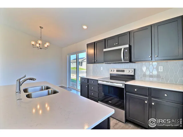 a kitchen with kitchen island a sink stainless steel appliances and cabinets