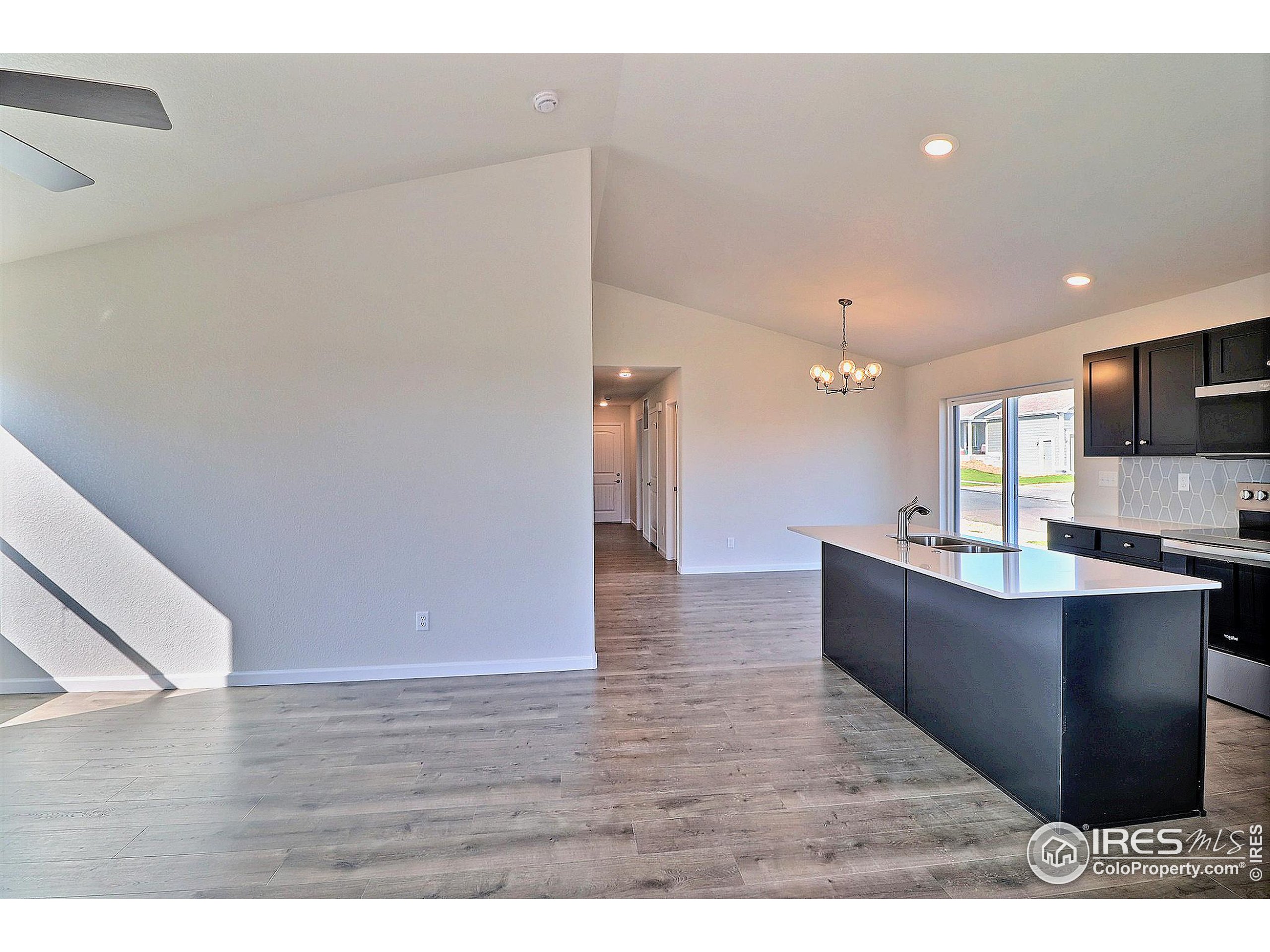 4301 Rockcress Road Evans, CO 80620 - Photo 5 of 26 a kitchen with stainless steel appliances a refrigerator and a wooden floor