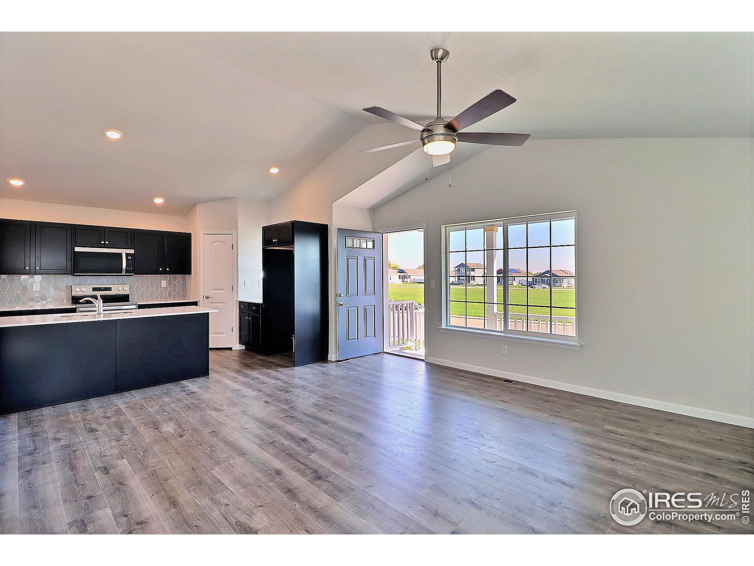 4301 Rockcress Road Evans, CO 80620 - Photo 6 of 26 a large kitchen with stainless steel appliances kitchen island a large counter top and sink