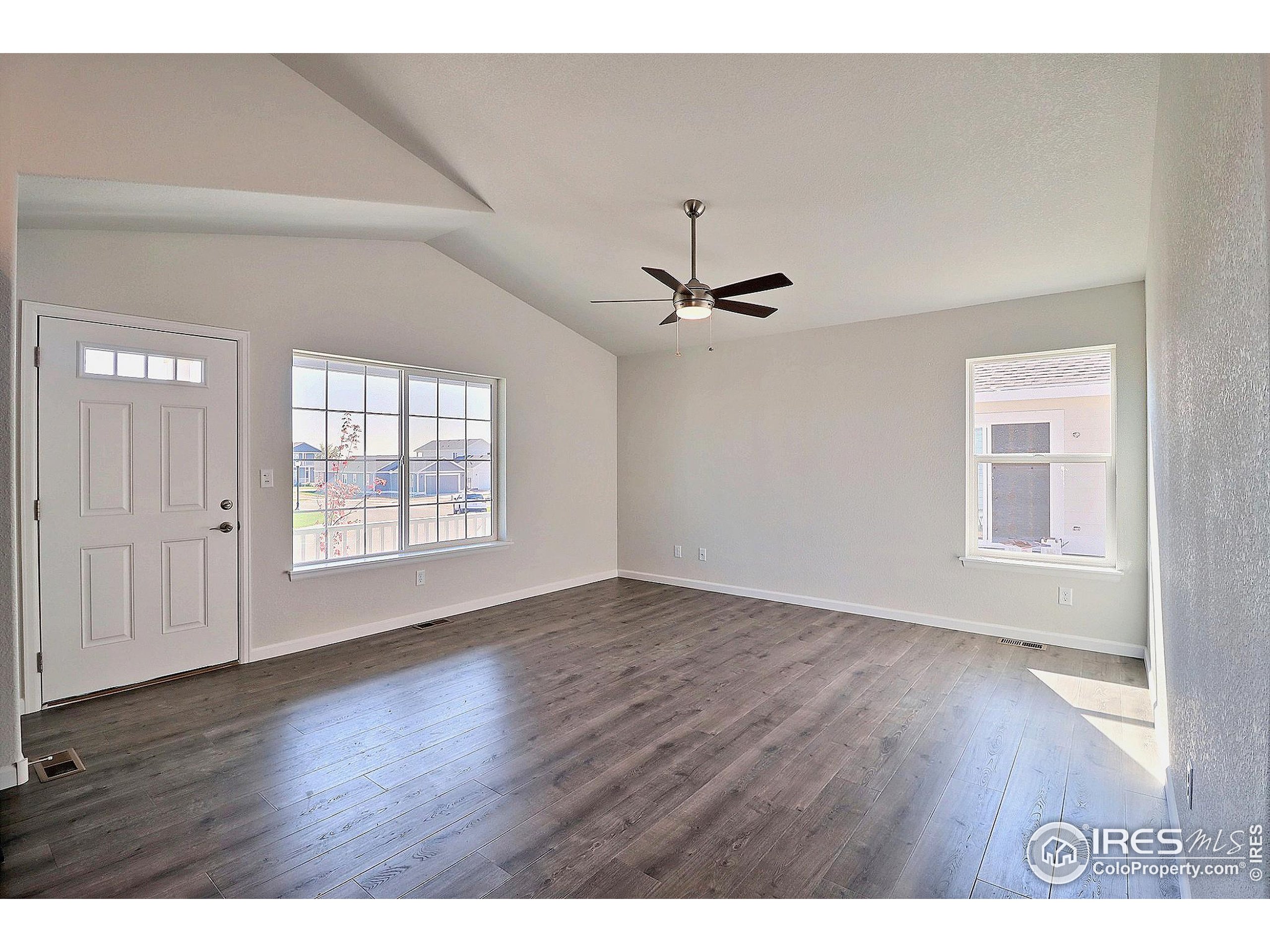 4301 Rockcress Road Evans, CO 80620 - Photo 7 of 26 a view of an empty room with a window and wooden floor
