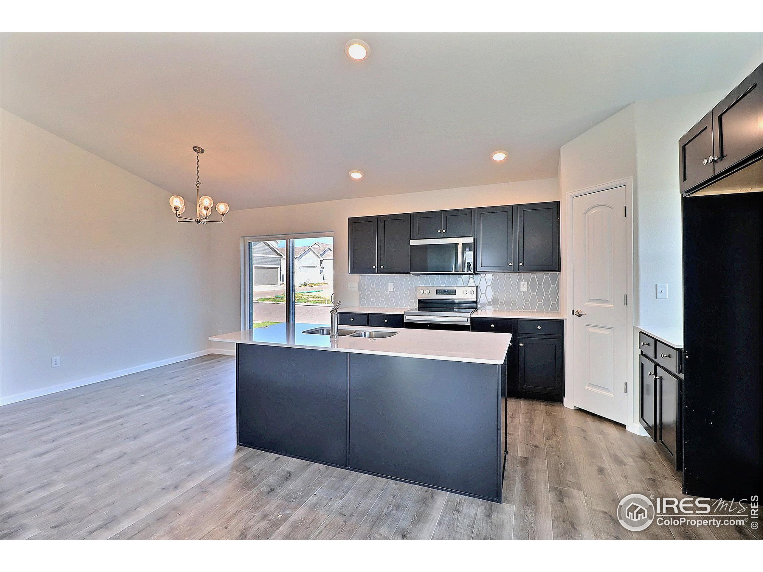 4301 Rockcress Road Evans, CO 80620 - Photo 8 of 26 a kitchen with granite countertop a stove top oven and refrigerator