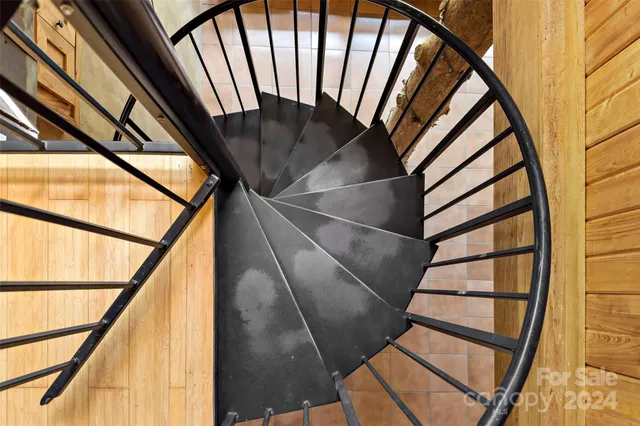 a view of staircase with railing and a window