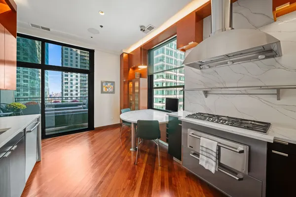a kitchen with a stove a sink and a wooden cabinets