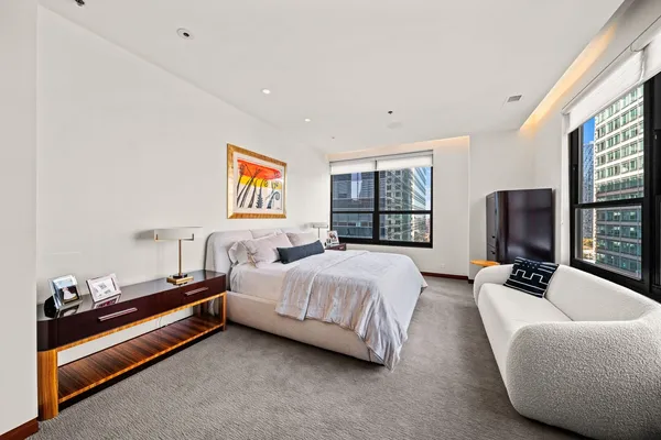 a spacious bedroom with a bed and a flat screen tv