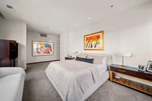 a spacious bedroom with a bed and a couch