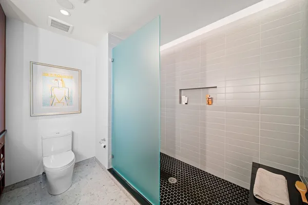 a bathroom with a toilet and a shower