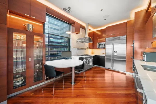 a dining room with wooden floor and large windows