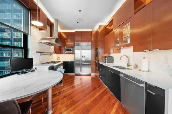 a open kitchen with stainless steel appliances granite countertop a sink a stove and wooden cabinets