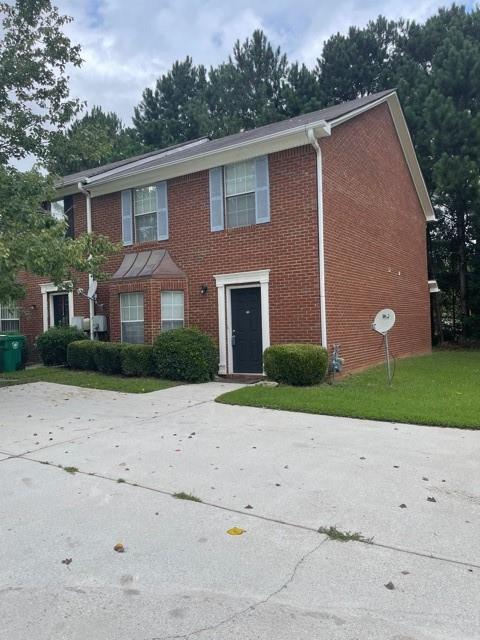 a front view of a house with a yard and a garage
