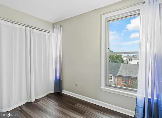 a view of an empty room with a window and a mirror