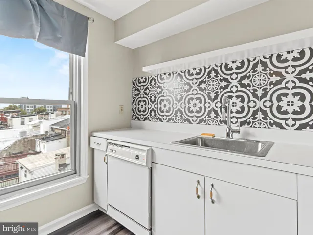 a view of a sink and a utility room with cabinets