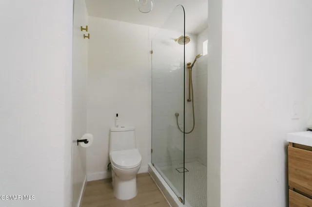 a bathroom with a granite countertop shower and a toilet