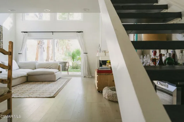 a living room with furniture and a floor to ceiling window
