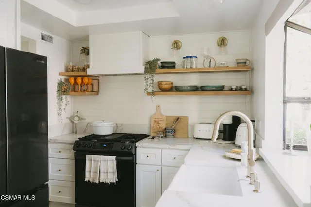a kitchen with a refrigerator and a stove