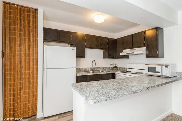 a kitchen with kitchen island a counter top space a sink stainless steel appliances and cabinets