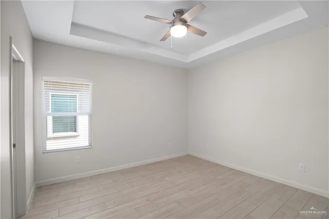 an empty room with a window and a fan