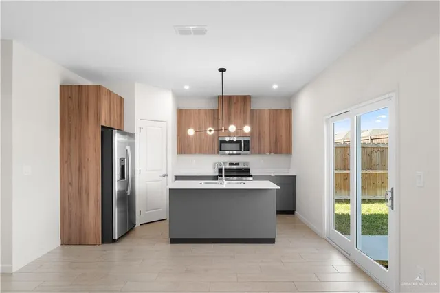 a kitchen with kitchen island a sink stainless steel appliances and cabinets