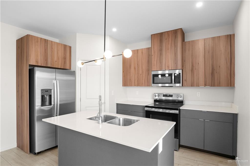 3416 Duke Avenue, Unit 3 McAllen, TX 78504 - Photo 5 of 15 a kitchen with stainless steel appliances a sink a stove a refrigerator and cabinets