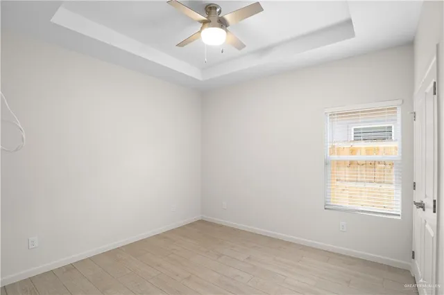 an empty room with a window and a fan