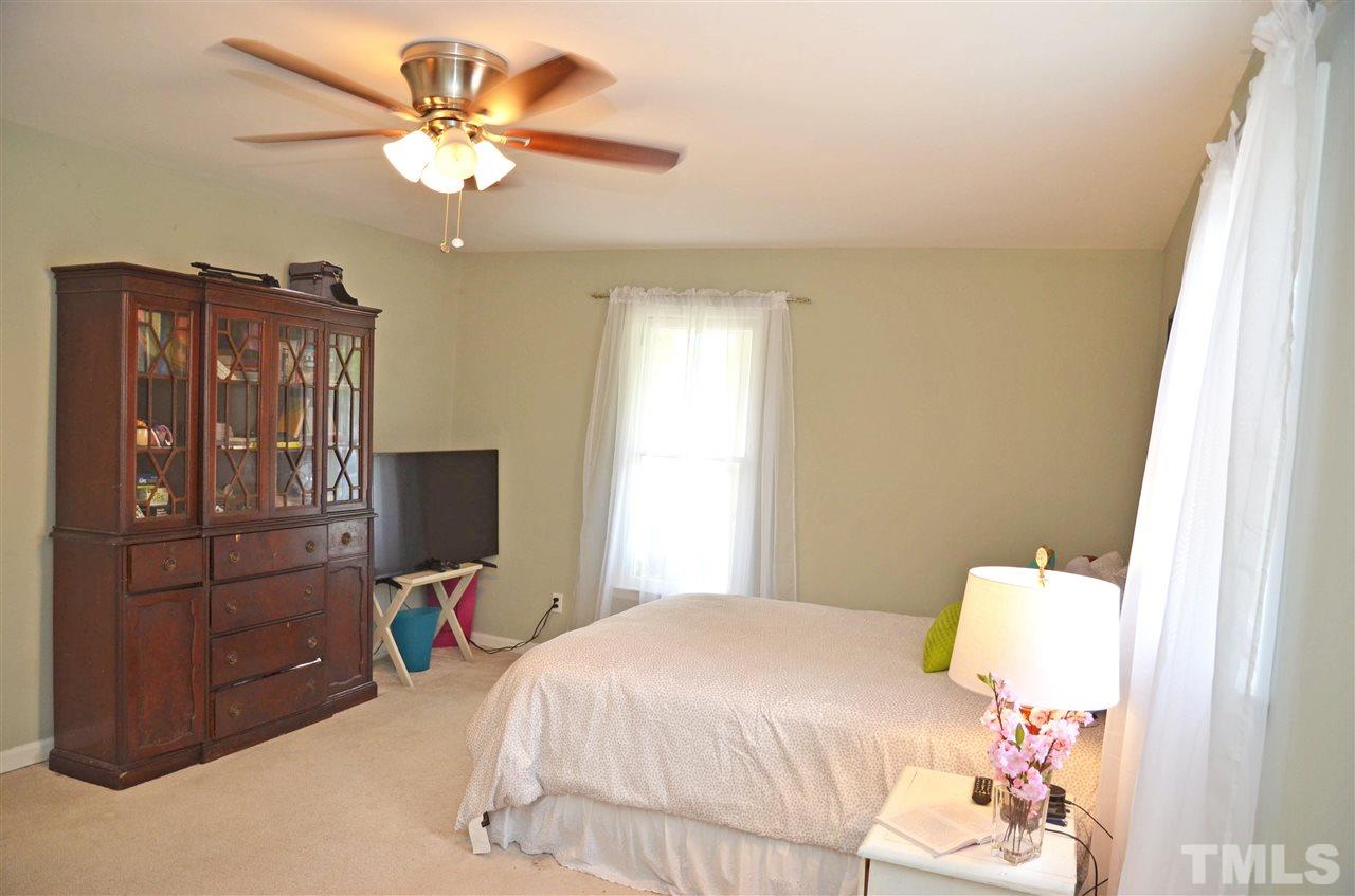 3913 Iron Horse Road Raleigh, NC 27616 - Photo 17 of 20 a bedroom with a bed and a chandelier