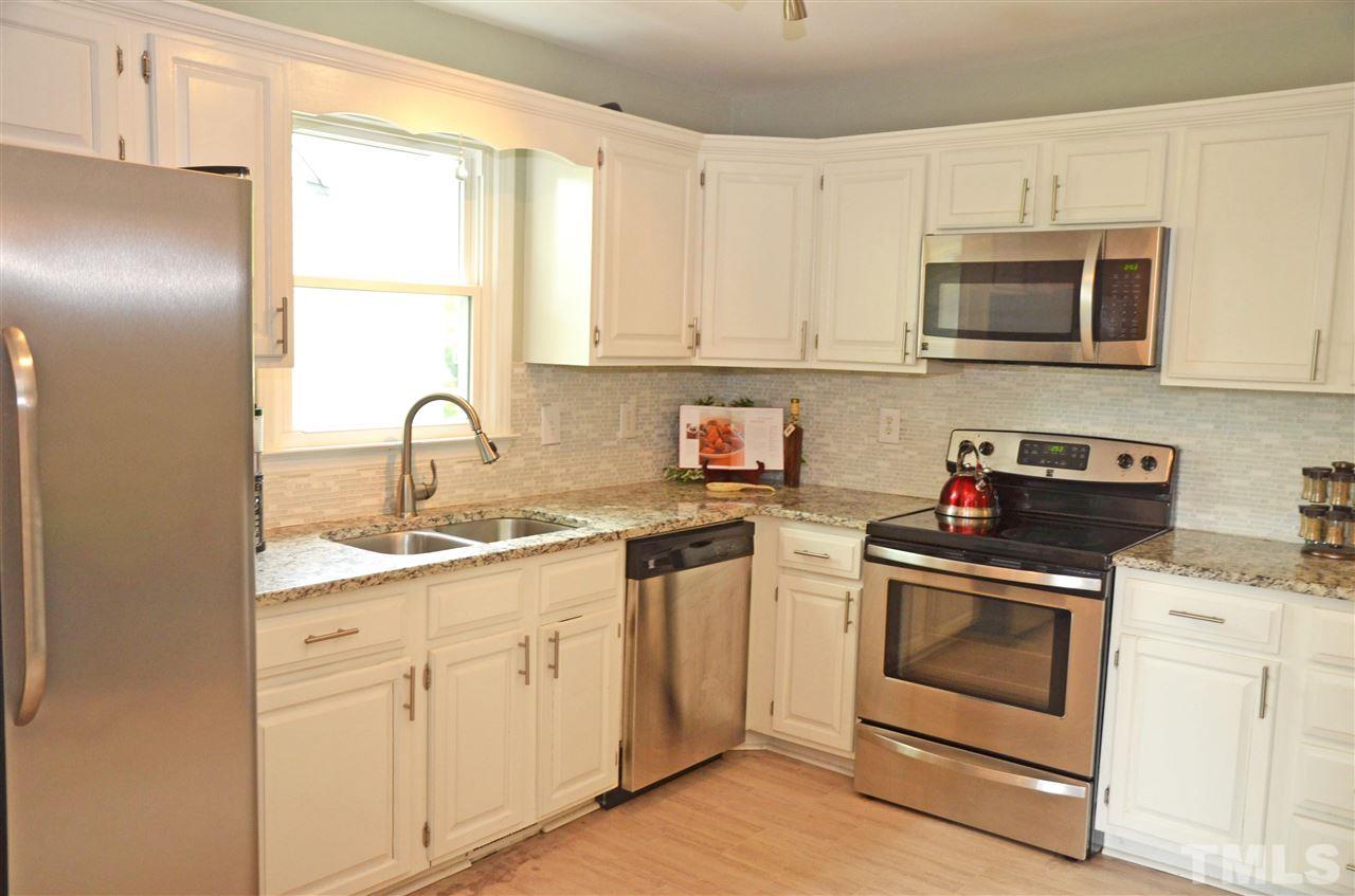 3913 Iron Horse Road Raleigh, NC 27616 - Photo 4 of 20 a kitchen with white cabinets stainless steel appliances and sink