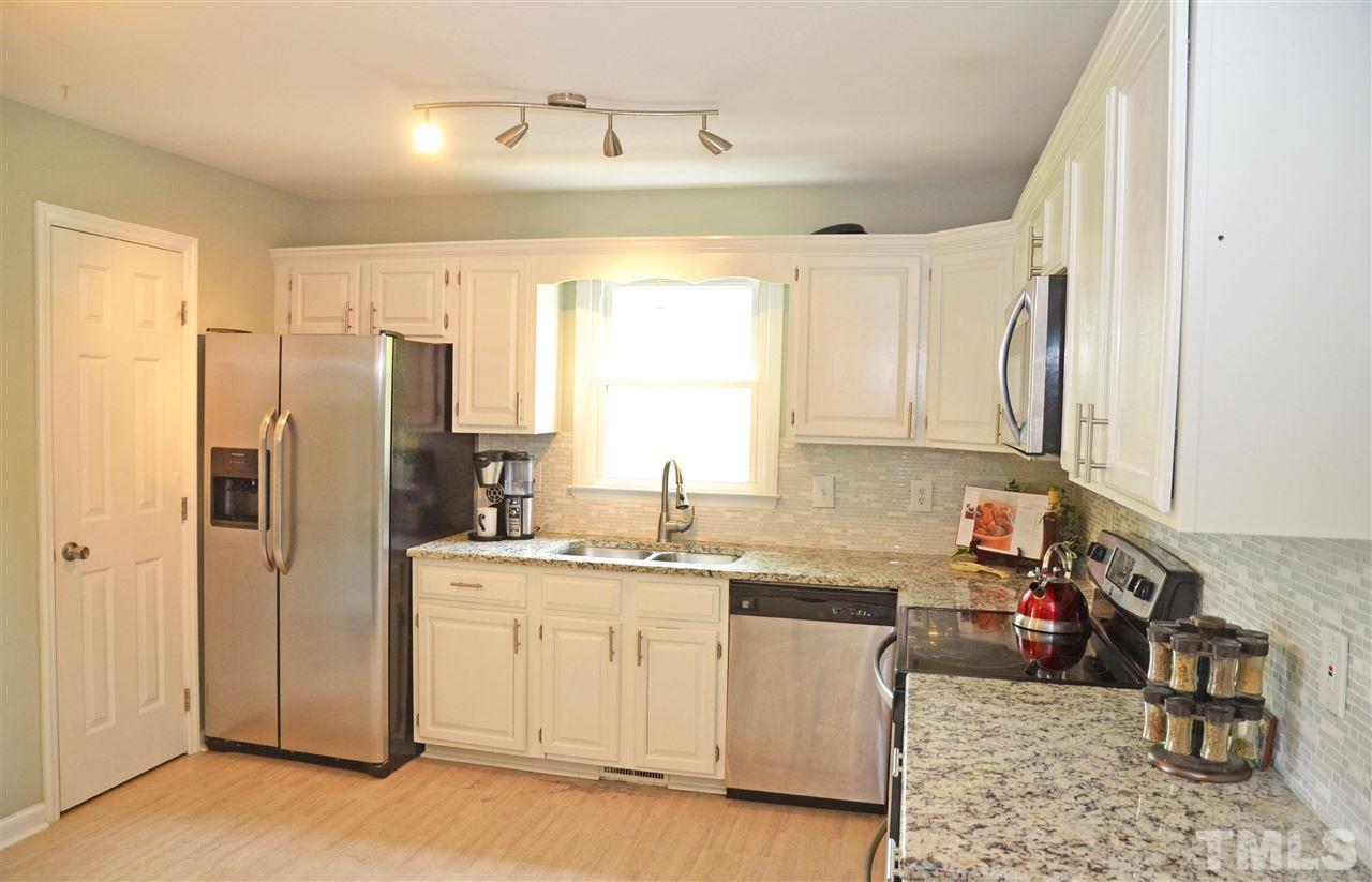 3913 Iron Horse Road Raleigh, NC 27616 - Photo 8 of 20 a kitchen with a sink dishwasher a refrigerator and cabinets