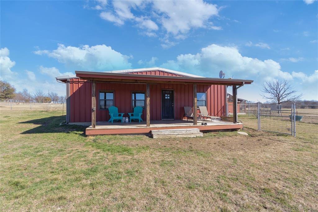 10306 Swafford Road Justin, TX 76247 - Photo 1 of 1 Back of property featuring board and batten siding, covered porch, and a gate