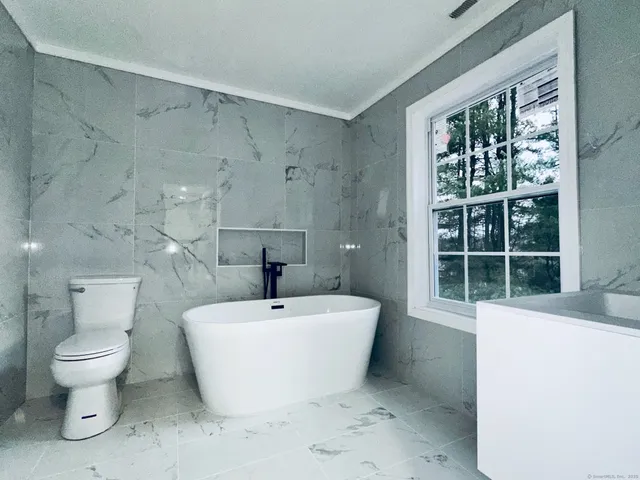 a white toilet sitting next to a bathroom sink