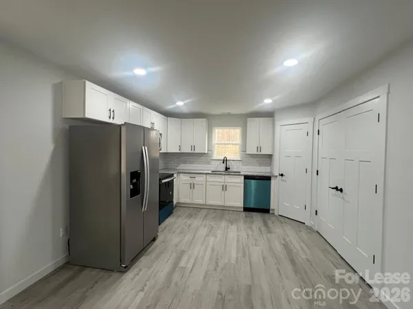 a kitchen with a refrigerator a sink and cabinets