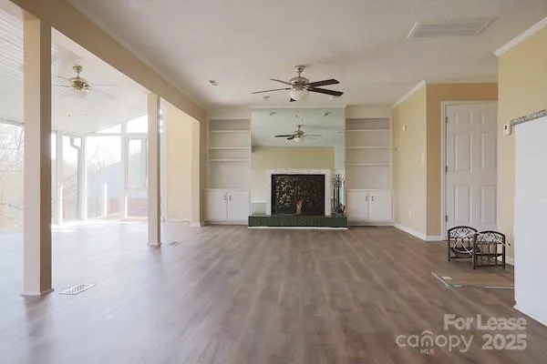 a view of an empty room with a fireplace and a window