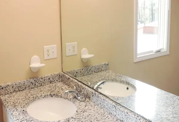 a bathroom with a granite countertop sink and a mirror