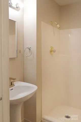 a bathroom with a sink a shower and a mirror