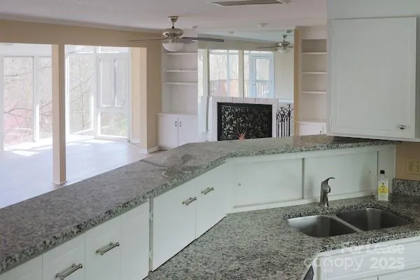 a kitchen with granite countertop a sink and a wooden floor