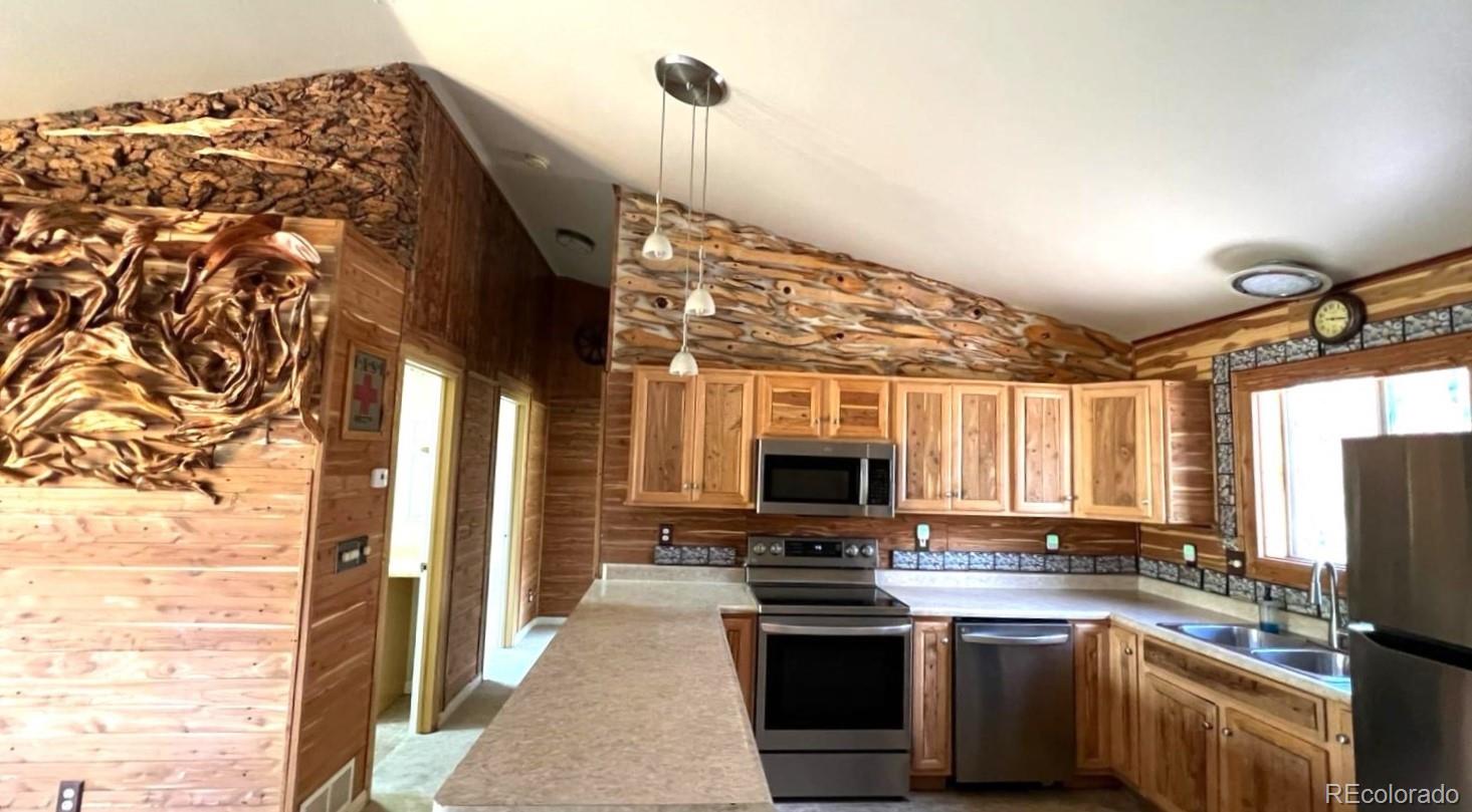 303 Virginia Road, Unit E Bailey, CO 80421 - Photo 4 of 16 a kitchen with stainless steel appliances a stove sink and microwave