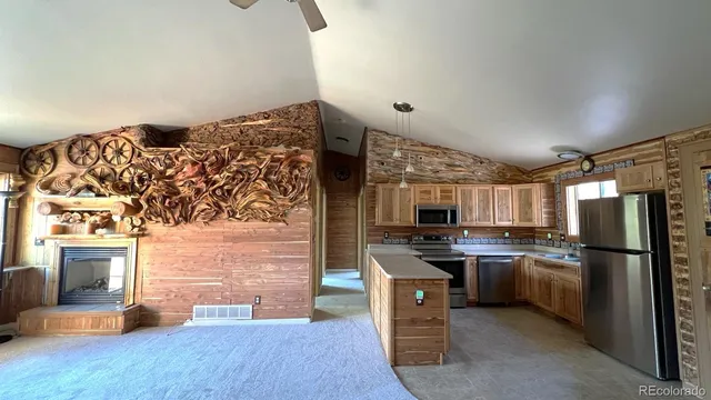 a kitchen with stainless steel appliances granite countertop a refrigerator a stove and a sink