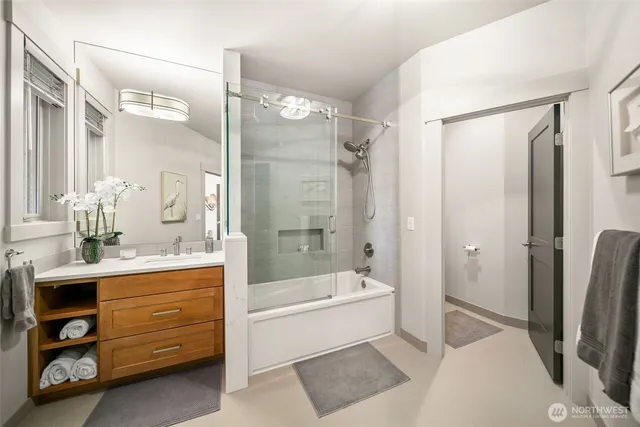 a bathroom with a tub a sink and a large mirror