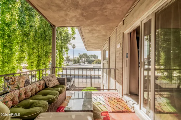 a balcony with furniture and a potted plant