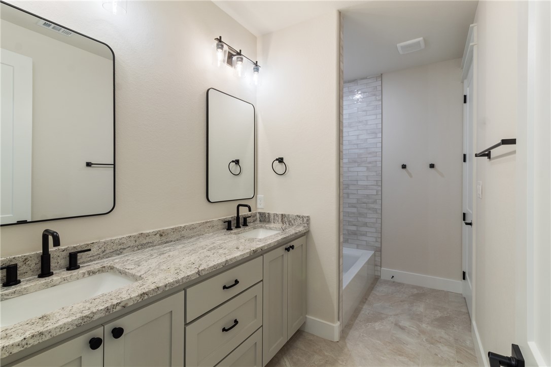 7822 Mathis Crk Drive Bryan, TX 77808 - Photo 26 of 43 a bathroom with a granite countertop sink and a mirror