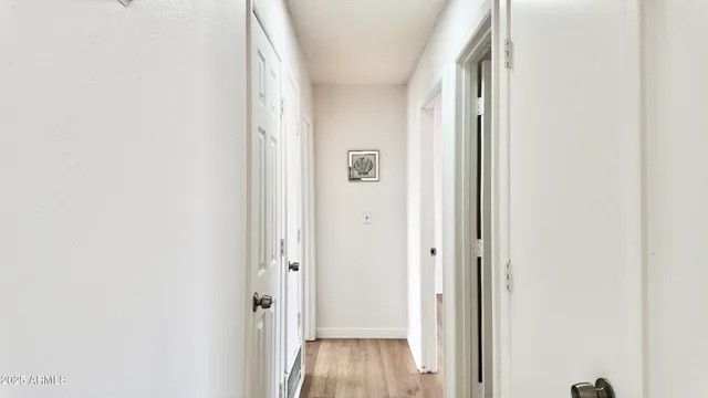 an empty room with wooden floor and closet area