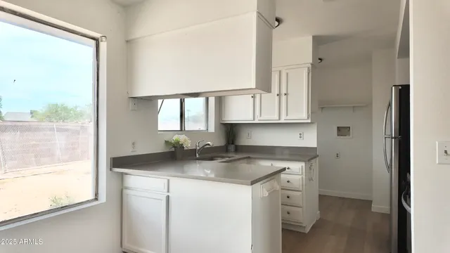 a view of a hallway with wooden floor and cabinet